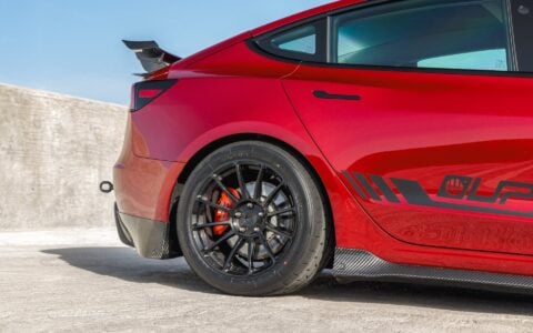 Side view of a 2024+ Tesla Model 3 Performance parked displaying Carbon Fiber Rear Sparts, Rear Dual Spoiler Wing and trunk spoiler, half of the side skirts showing. and UP-03 Forged Wheels.