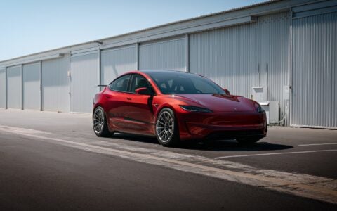 2024 Tesla Model 3 Performance in Ultra Red with UP-03 Pikes Peak Forged Wheels by Unplugged Performance, showcasing its aggressive stance and enhanced aerodynamics.