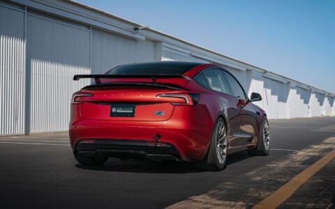 Rear view of a 2024 Tesla Model 3 Performance in Ultra Red with UP-03 Pikes Peak Forged Wheels by Unplugged Performance, showcasing its aggressive stance and enhanced aerodynamics.