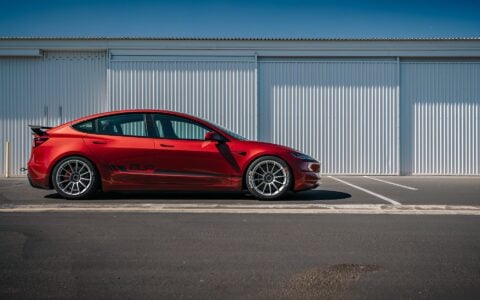 2024 Tesla Model 3 Performance in Ultra Red with UP-03 Pikes Peak Forged Wheels by Unplugged Performance, showcasing its aggressive stance and enhanced aerodynamics.