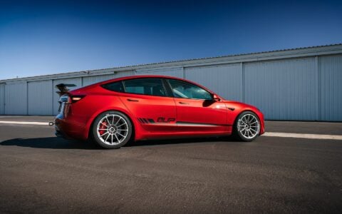 2024 Tesla Model 3 Performance in Ultra Red with UP-03 Pikes Peak Forged Wheels by Unplugged Performance, showcasing its aggressive stance and enhanced aerodynamics.