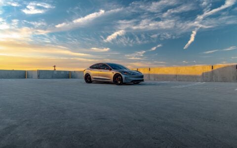 A Quicksilver Tesla Model 3 Performance parked with UP-05 Forged Wheels in a vacant parking lot.