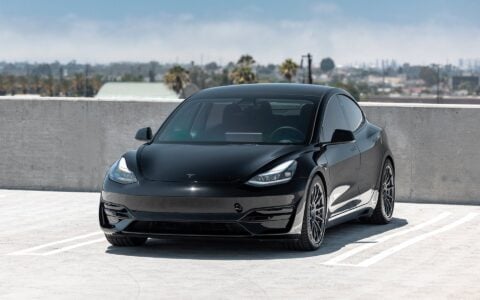 Black Tesla Model 3 Performance, showcasing an aggressive low stance achieved with Unplugged Performance dual rate lowering springs and Satin Titanium UP-03 forged wheels.