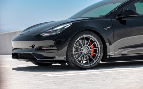 Black Tesla Model 3 Performance equipped with Satin Titanium UP-03 wheels and Unplugged Performance lowering springs for a sleek stance.