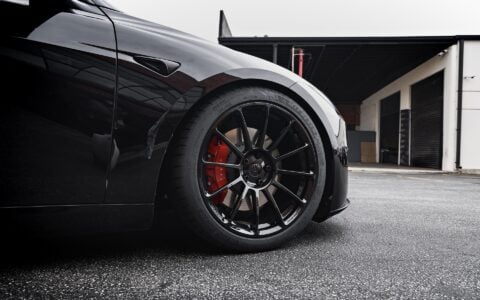Front close-up shot of Tesla Model 3 Performance showcasing UP-03 Forged Wheels in Gloss Black by Unplugged Performance, paired with Michelin Pilot Sport 4S tires and red Tesla brake calipers.