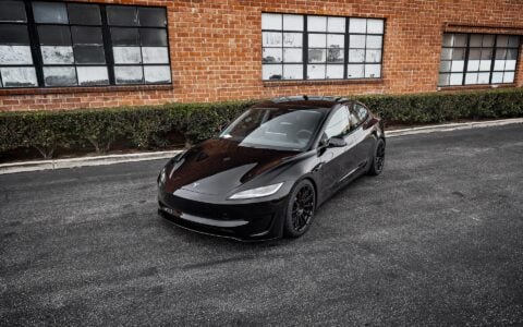 3/4 view of Tesla Model 3 Performance in an industrial setting, equipped with UP-03 Forged Wheels by Unplugged Performance, blending luxury and performance.