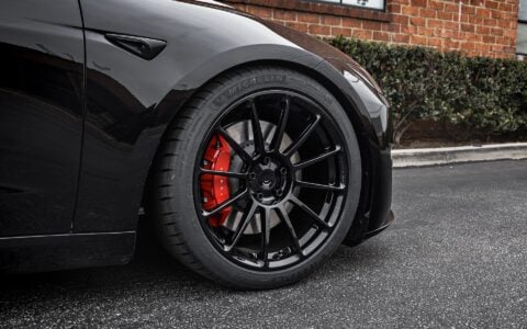Close-up shot of Tesla Model 3 Performance showcasing UP-03 Forged Wheels in Gloss Black by Unplugged Performance, paired with Michelin Pilot Sport 4S tires and red Tesla brake calipers.