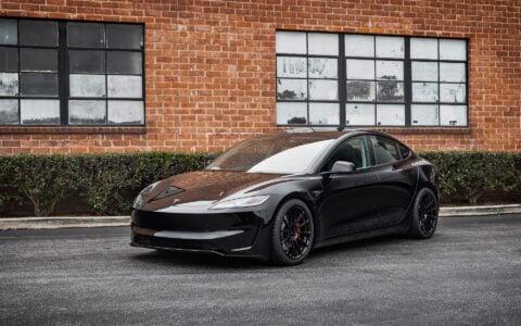 Tesla Model 3 Performance parked in an urban setting, equipped with UP-03 Forged Wheels by Unplugged Performance, offering a dynamic and aggressive appearance.