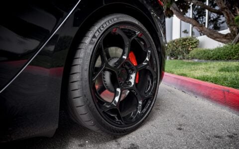 Close-up shot of Tesla Model 3 Performance showcasing UP-05 Forged Wheels in Gloss Black by Unplugged Performance, paired with Michelin Pilot Sport 4S tires and red Tesla brake calipers.