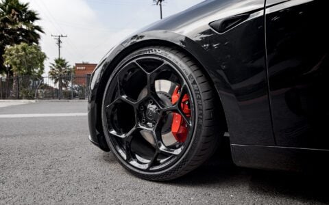 Close-up shot of Tesla Model 3 Performance showcasing UP-05 Forged Wheels in Gloss Black by Unplugged Performance, paired with Michelin Pilot Sport 4S tires and red Tesla brake calipers.