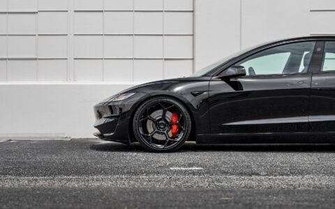 Side view of Tesla Model 3 Performance in an industrial setting, equipped with UP-03 Forged Wheels by Unplugged Performance.