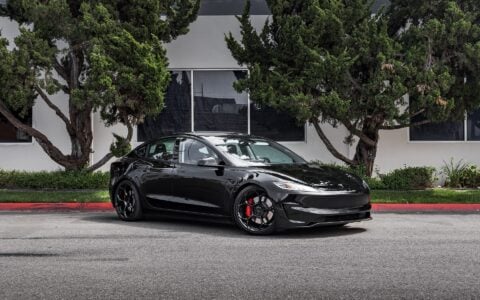 Tesla Model 3 Performance parked in an urban setting, equipped with UP-05 Forged Wheels by Unplugged Performance, offering a dynamic and aggressive appearance.