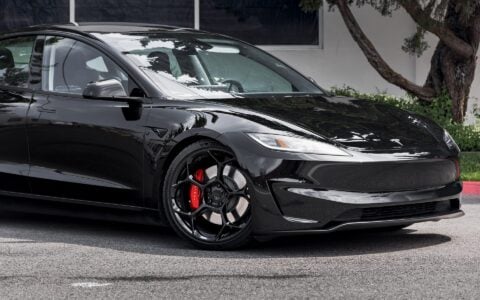 Angled view of Tesla Model 3 Performance in an industrial setting, equipped with UP-05 Forged Wheels by Unplugged Performance, blending luxury and performance.