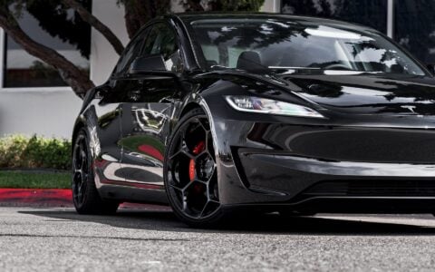 Close up view of Tesla Model 3 Performance in an industrial setting, equipped with UP-05 Forged Wheels by Unplugged Performance, blending luxury and performance.