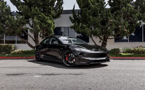 Side view of Tesla Model 3 Performance in an industrial setting, equipped with UP-05 Forged Wheels by Unplugged Performance, blending luxury and performance.