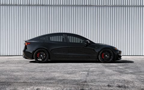 Side profile of a black Tesla Model 3 Performance, featuring Unplugged Performance's UP X BBS Flugplatz Wheels in Gloss Black, enhanced with a lowered stance.