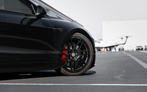 Front view of a Tesla Model 3 Performance sporting UP X BBS Flugplatz Wheels in Gloss Black by Unplugged Performance, with high-performance brakes visible through the spokes.