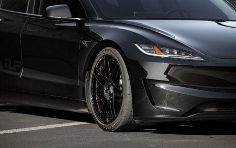 2024 Tesla Model 3 Performance lowered with UP X BBS Flugplatz Wheels in Gloss Black by Unplugged Performance, parked on a tarmac.