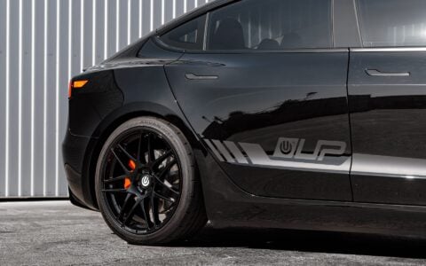 Detailed shot of the rear wheel on a Tesla Model 3 Performance showcasing UP X BBS Flugplatz Wheels in Gloss Black by Unplugged Performance, fitted with high-performance Yokohama Advan Apex tires.