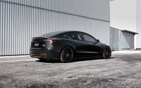 Rear three-quarter angle of Tesla Model 3 Performance showcasing UP X BBS Flugplatz Wheels in Gloss Black by Unplugged Performance, providing a dynamic and aggressive stance.