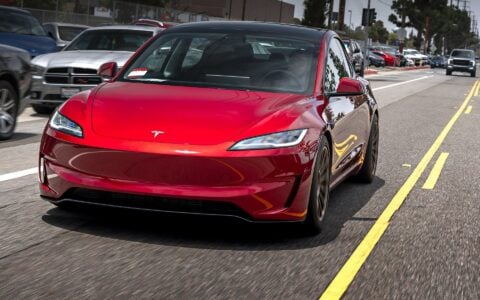 Angled shot of a Tesla Model 3 Performance with 18 inch Satin Bronze UP-03 driving up the street.