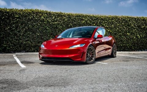 2024 Tesla Model 3 Performance in Ultra Red, parked and showcasing the 18-inch Satin Bronze UP-03 Forged Wheels by Unplugged Performance.