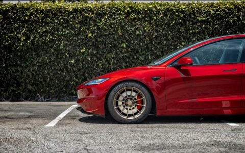 Close-up of the front 18-inch Satin Bronze UP-03 Forged Wheel on a 2024 Ultra Red Tesla Model 3 Performance by Unplugged Performance.