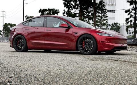 Profile view of an Ultra Red Tesla Model 3 Performance equipped with 19-inch Gloss Black UP-03 forged wheels by Unplugged Performance parked.